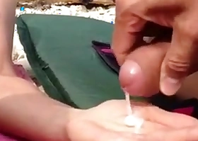 Une femme nudiste leche le sperme a la plage